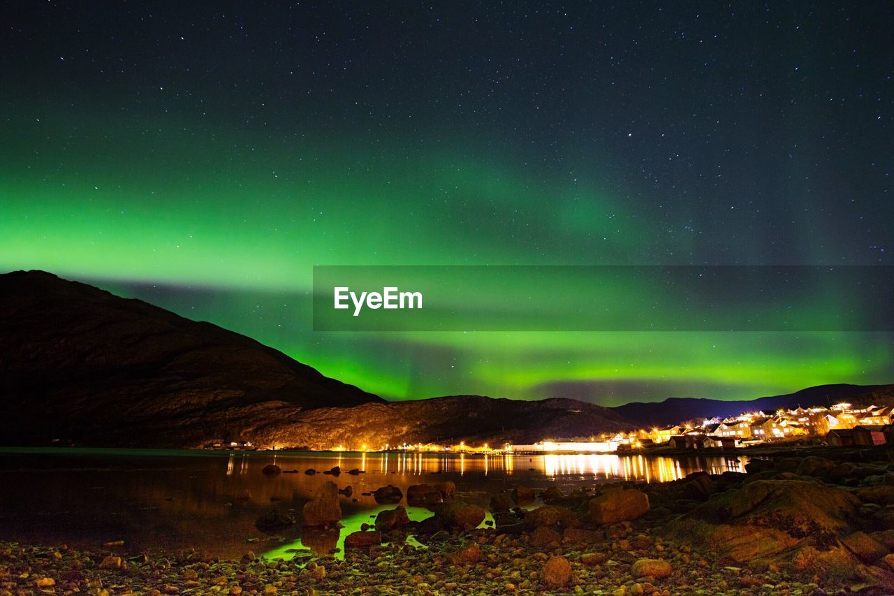 Scenic view of illuminated mountains against sky at night