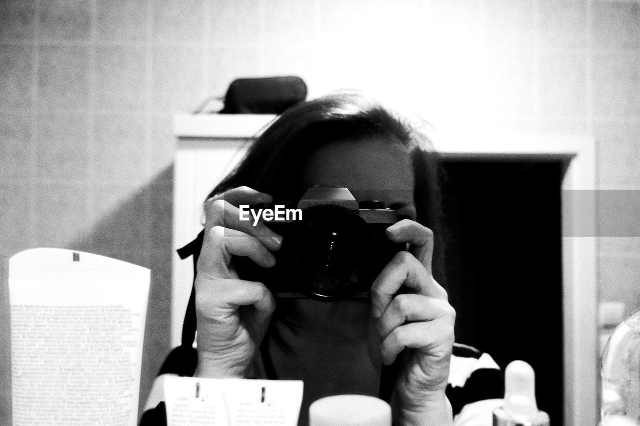 PORTRAIT OF WOMAN PHOTOGRAPHING CAMERA