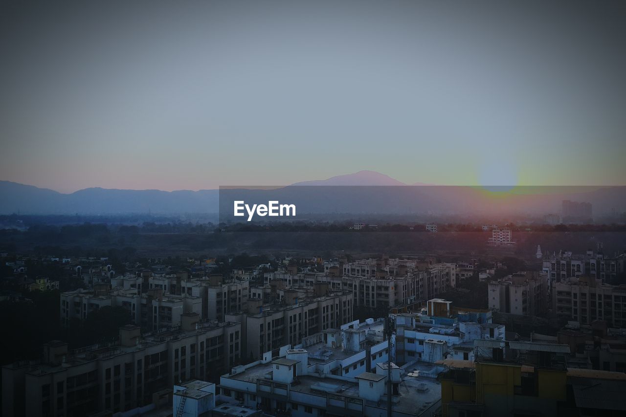 High angle view of buildings in city at sunset