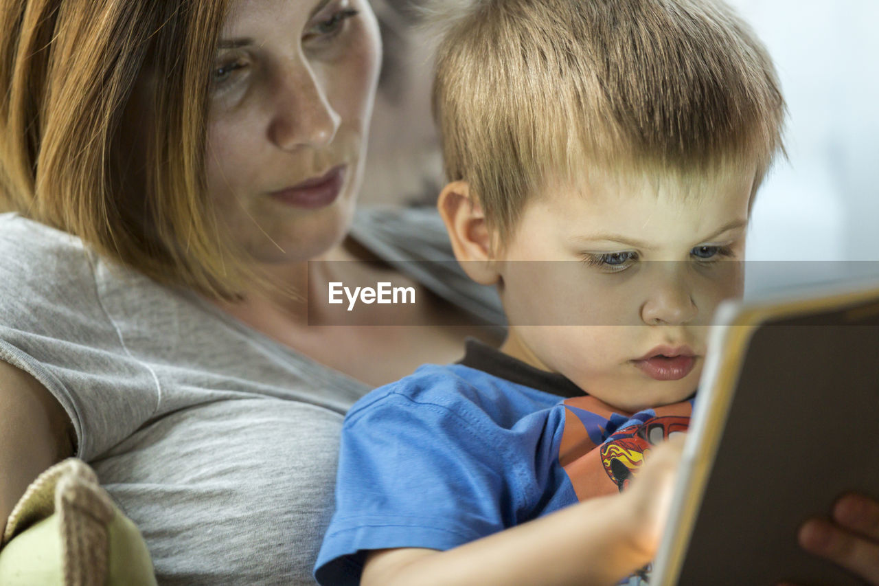 Close-up of mother and boy with digital tablet