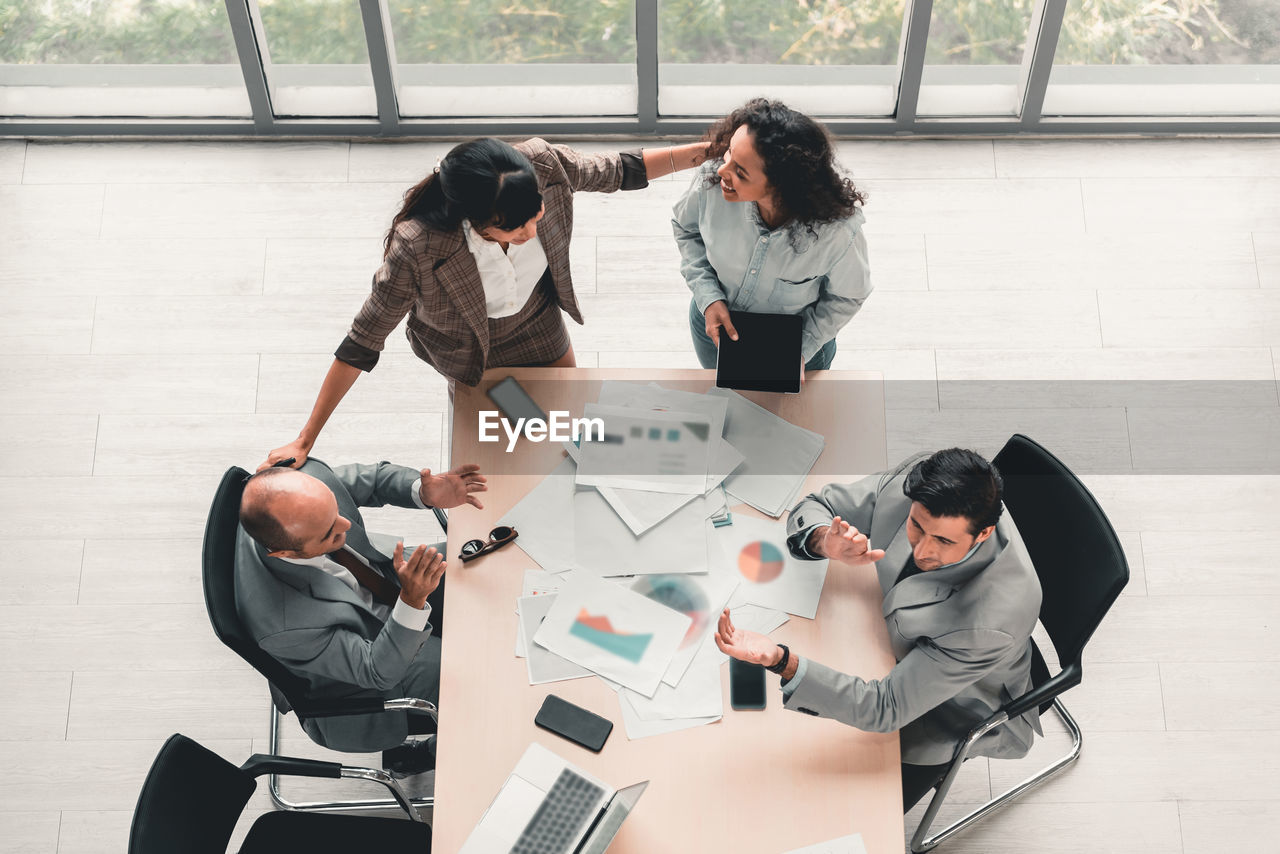 High angle view of business colleagues discussing at office