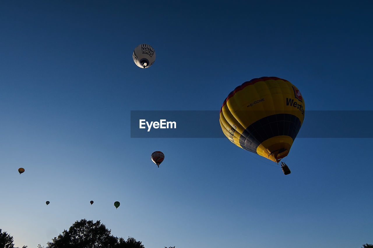 LOW ANGLE VIEW OF HOT AIR BALLOONS IN SKY