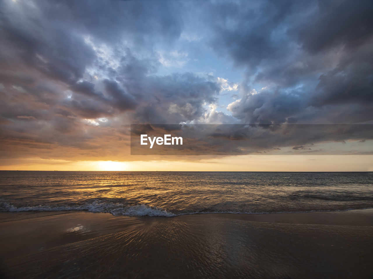 scenic view of sea against cloudy sky during sunset