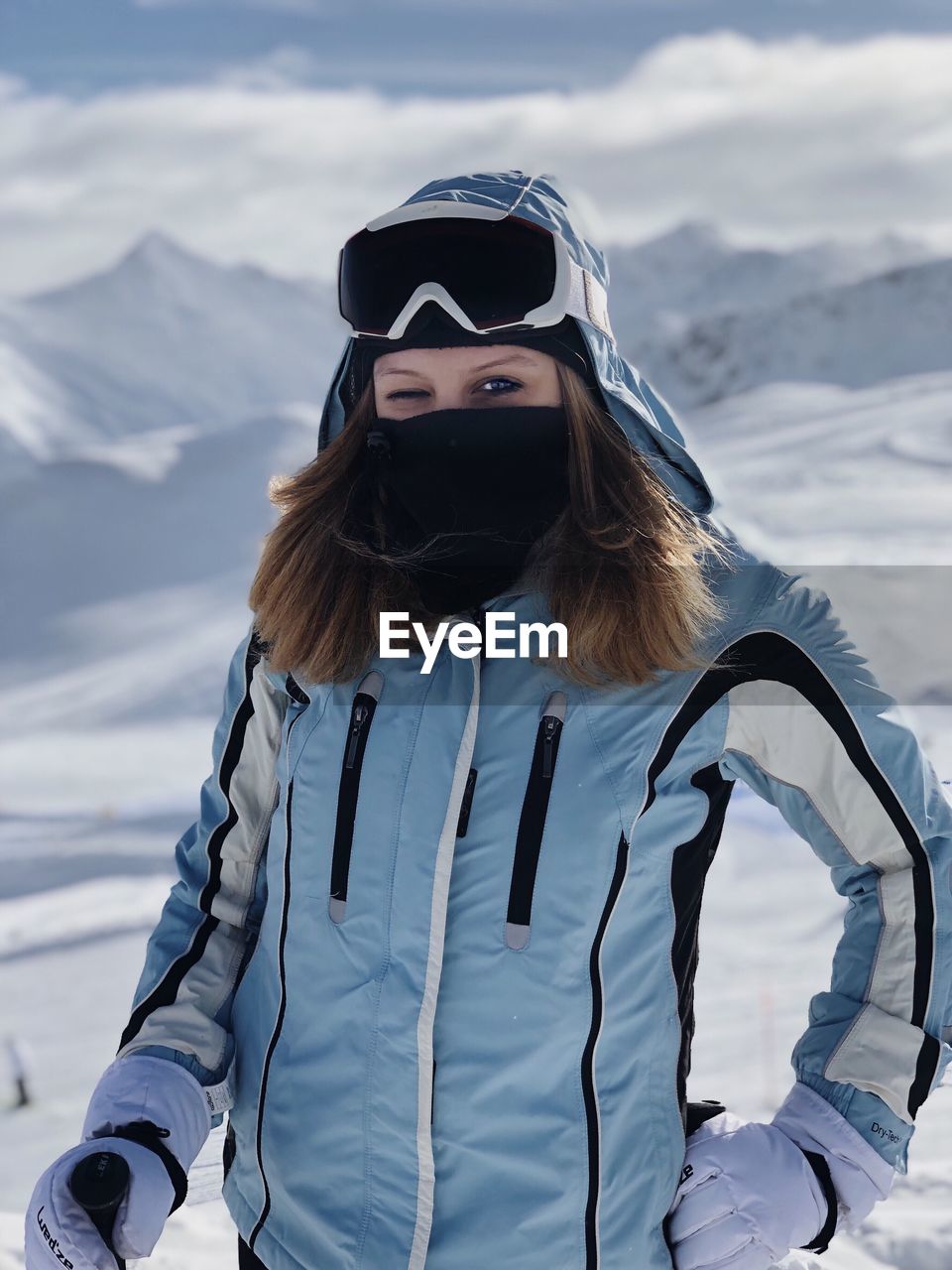 Portrait of woman standing on snow covered mountain