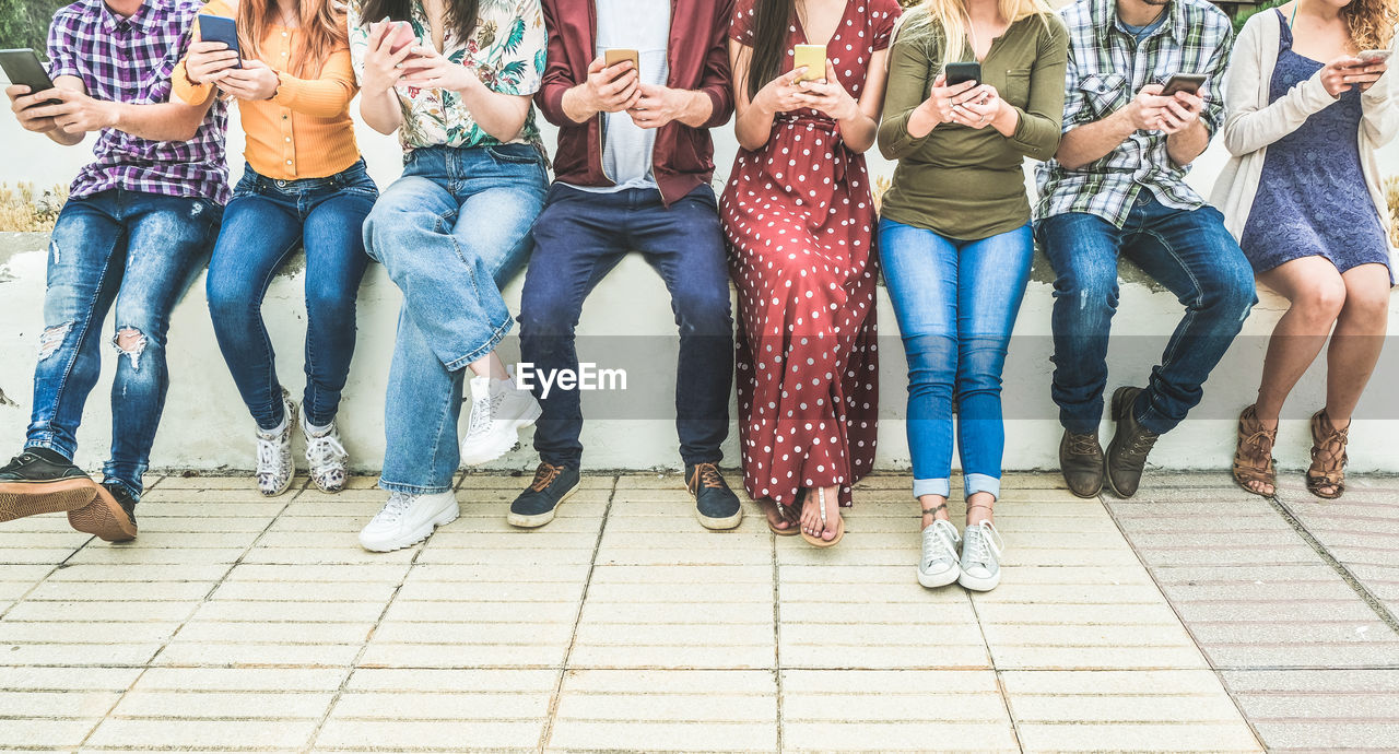 Low section of people sitting on retaining wall