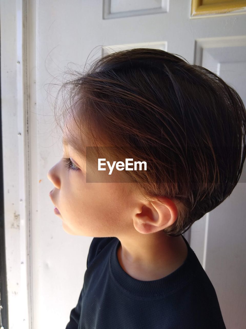 Close-up of boy looking away at home