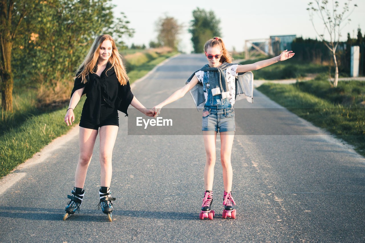 Friends roller skating on road