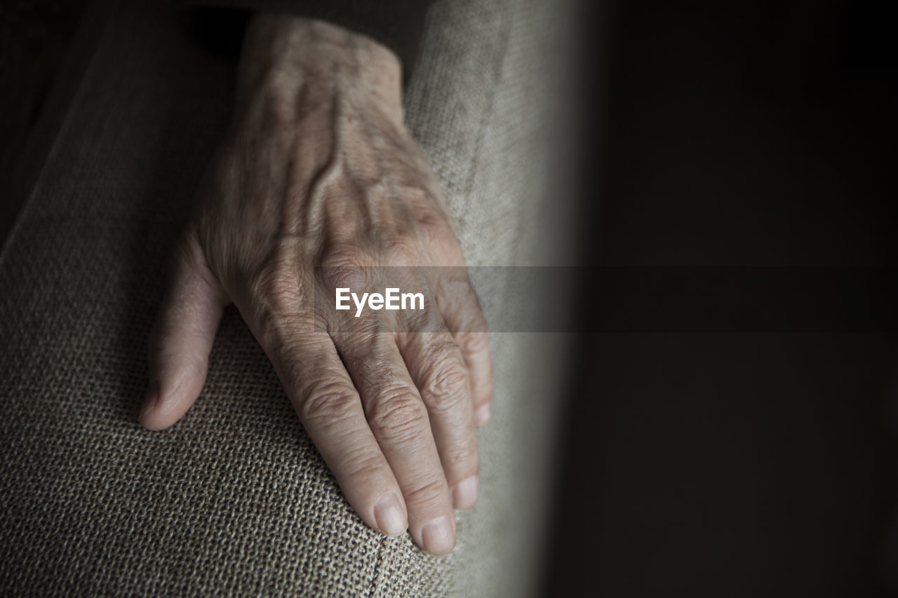 Close-up of person hand on armrest