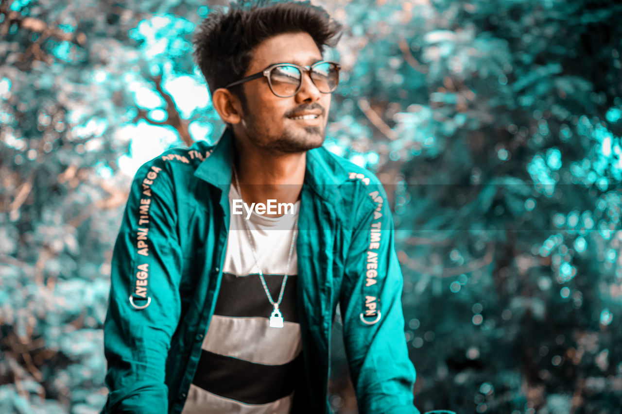 PORTRAIT OF YOUNG MAN WEARING EYEGLASSES