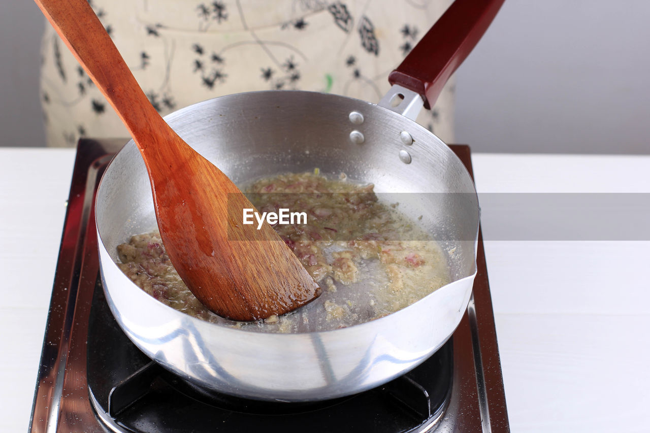 kitchen utensil, food and drink, food, household equipment, spoon, indoors, wooden spoon, dish, eating utensil, wood, cooking pan, ladle, cuisine, freshness, kitchen, domestic room, no people, close-up, preparing food, baked, wellbeing, healthy eating, pan, appliance, high angle view
