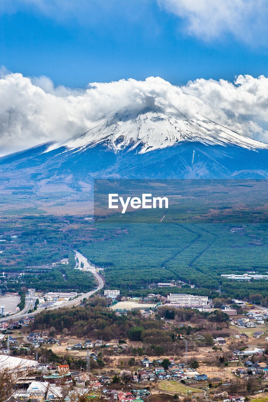 Aerial view of landscape and mountains against blue sky