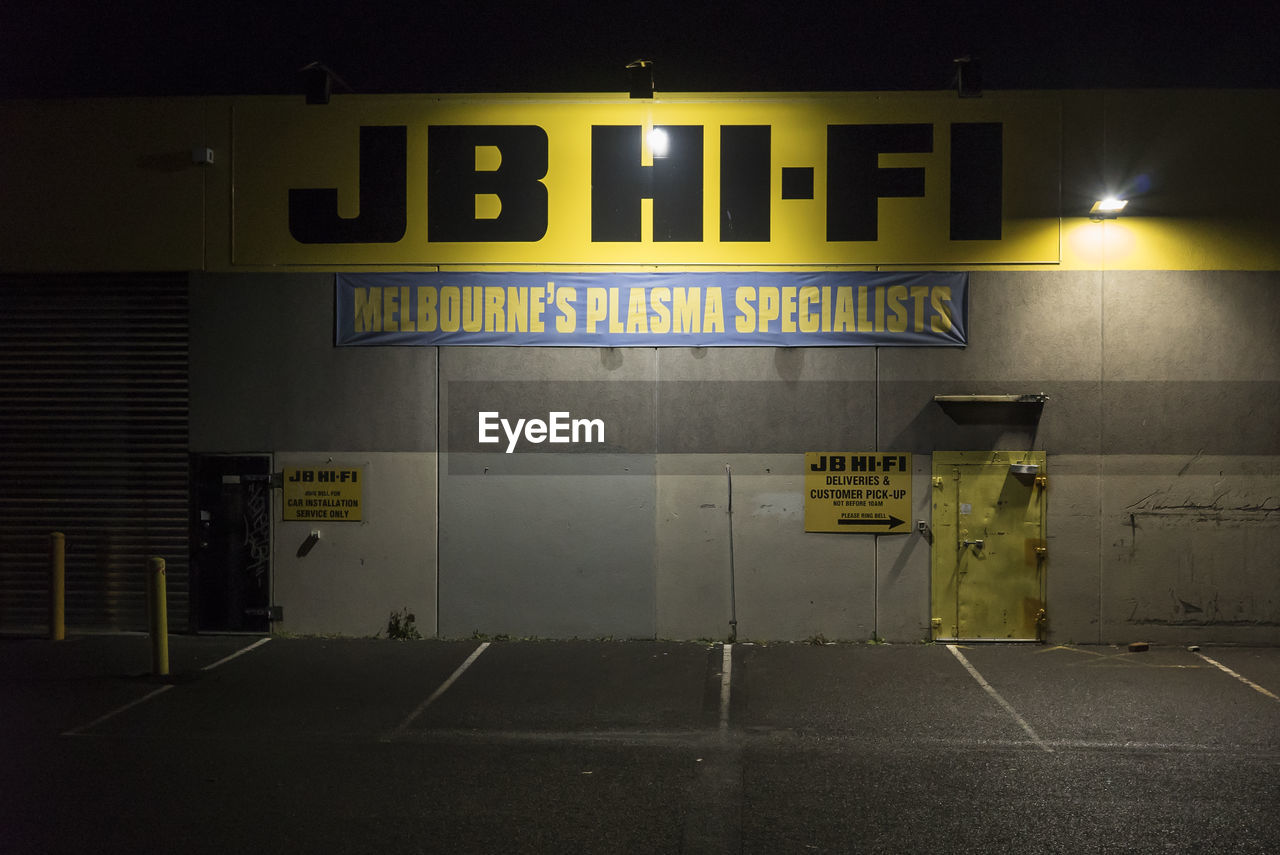 SIGN BOARD ON ROAD AT NIGHT