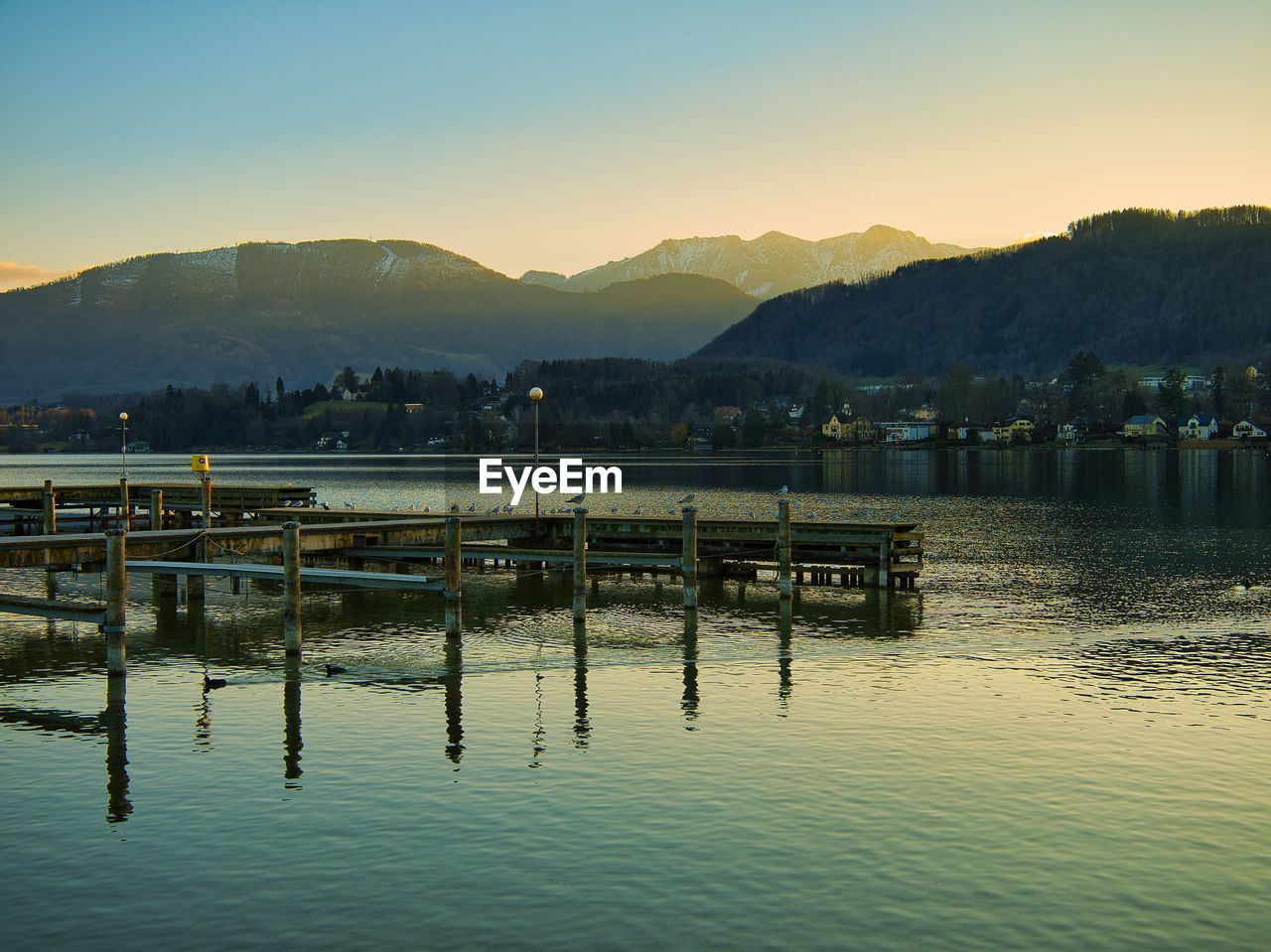 PIER ON LAKE AGAINST SKY DURING SUNSET