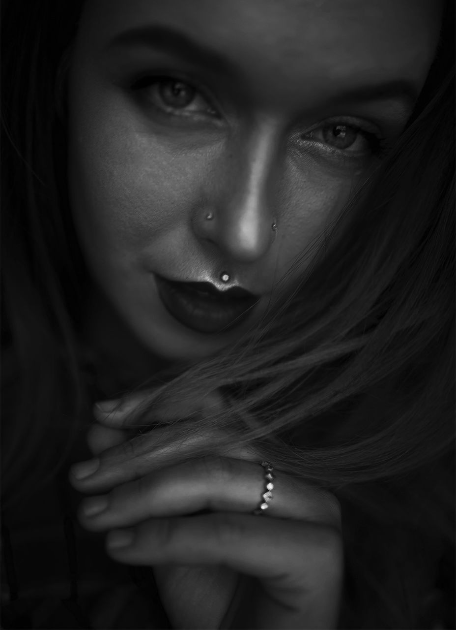 Close-up portrait of beautiful woman against black background