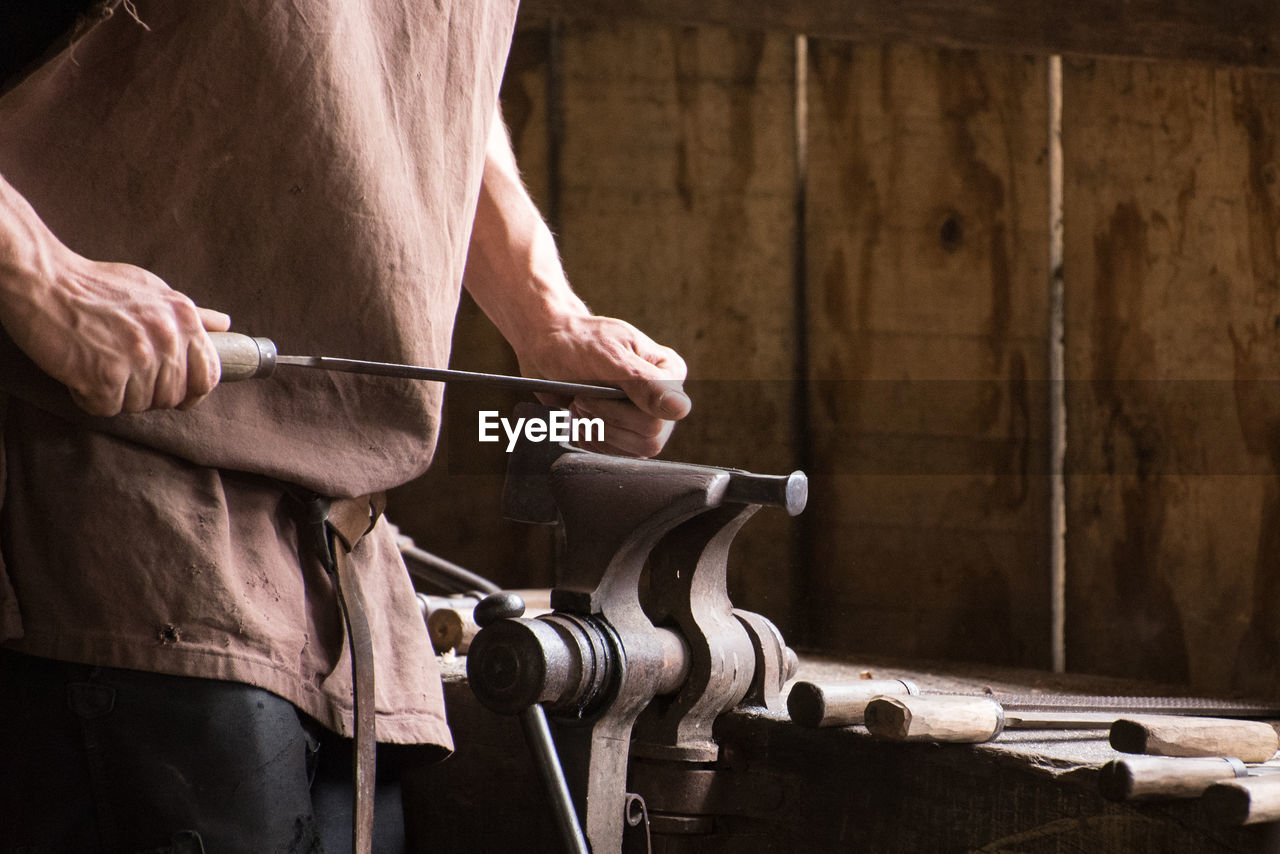 Midsection of man working in workshop