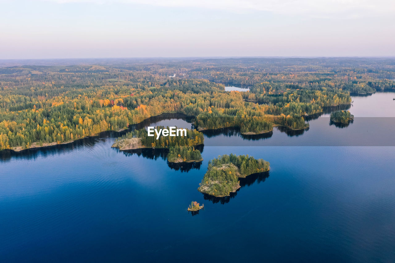 High angle view of lake against sky. islands with fall color forest and blue water.