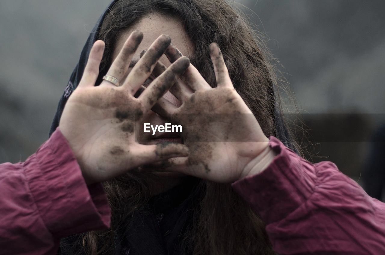 Close-up of young woman showing dirty hands