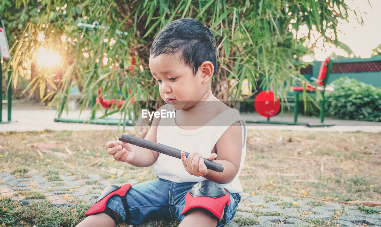 BOY PLAYING WITH MAN SITTING IN BACKGROUND