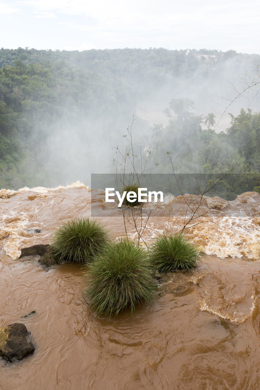 Scenic view of waterfall against sky