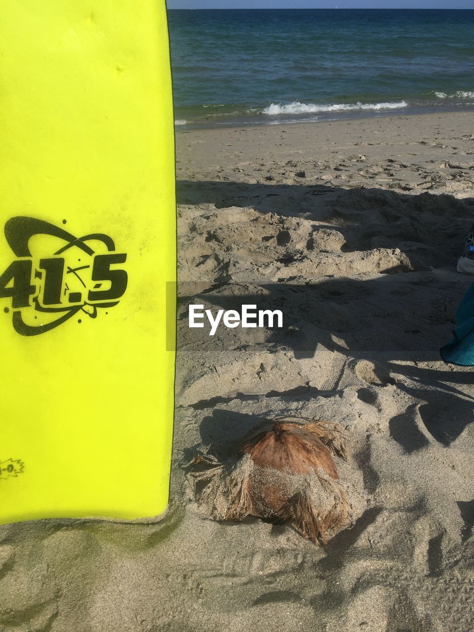 HIGH ANGLE VIEW OF YELLOW TEXT ON BEACH