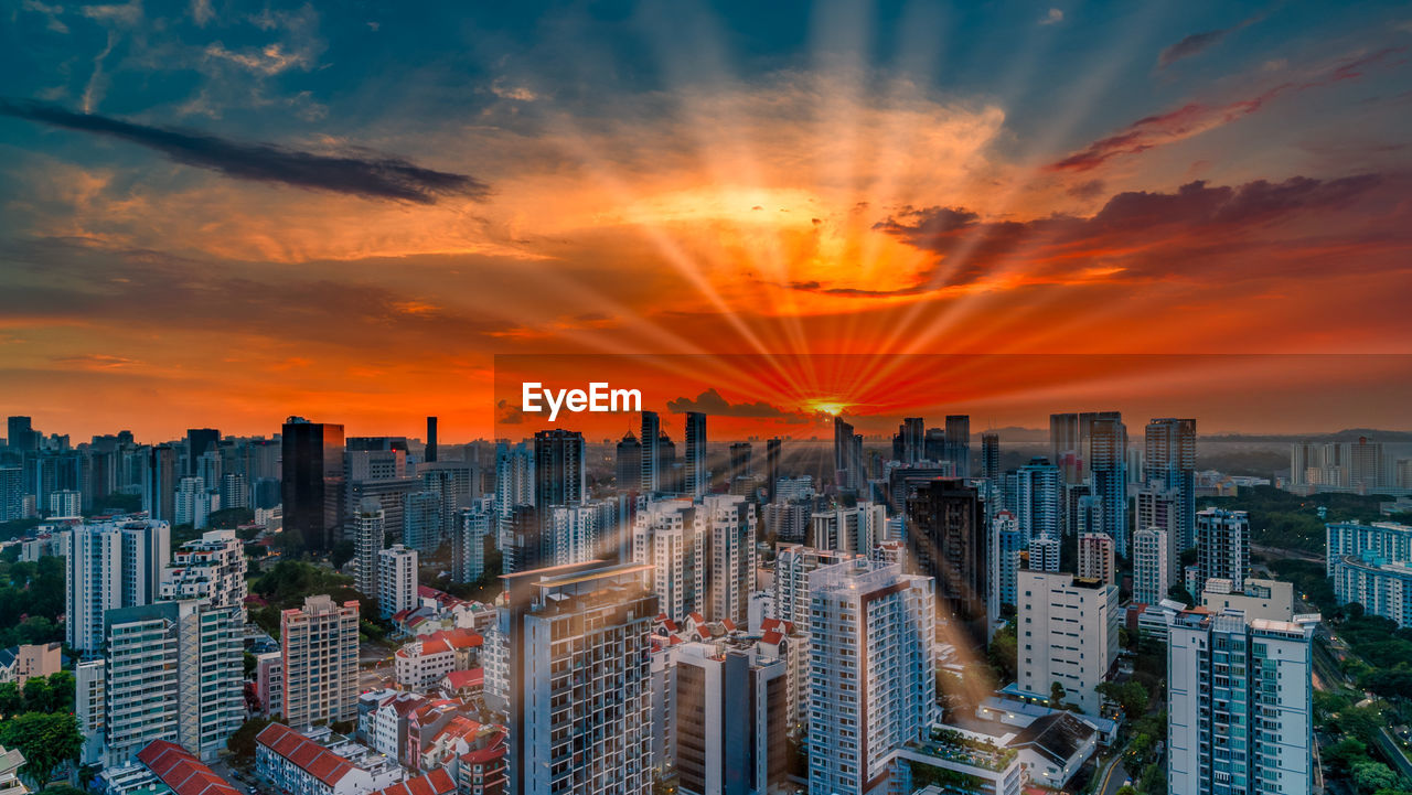 Aerial view of modern buildings against sky during sunset