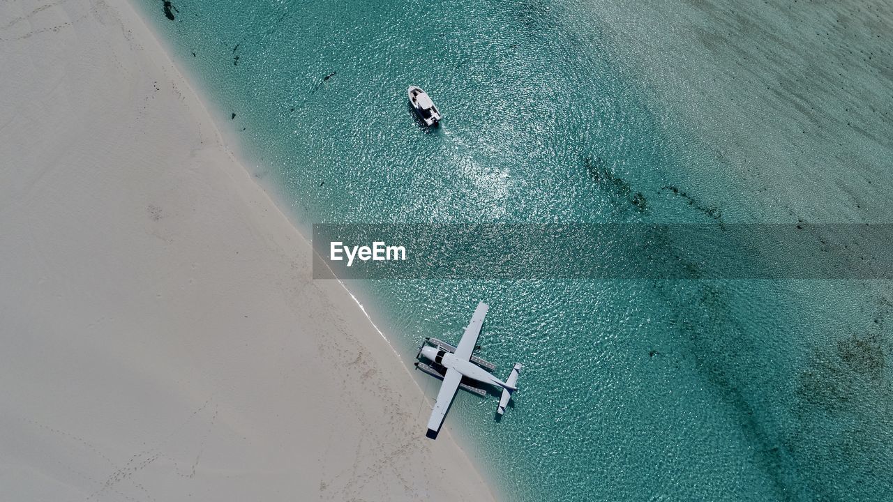 Aerial view of seaplane and boat in sea