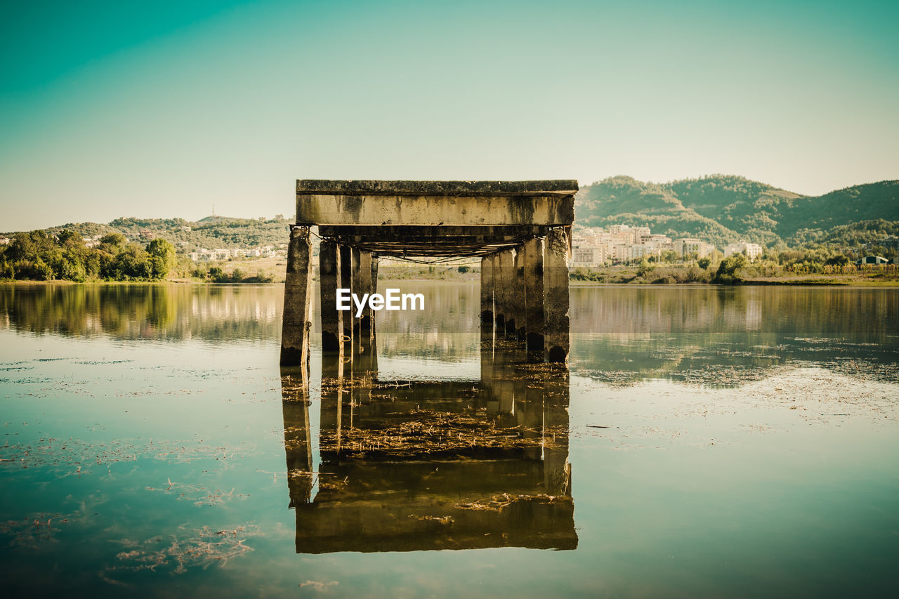 Built structure in lake against sky