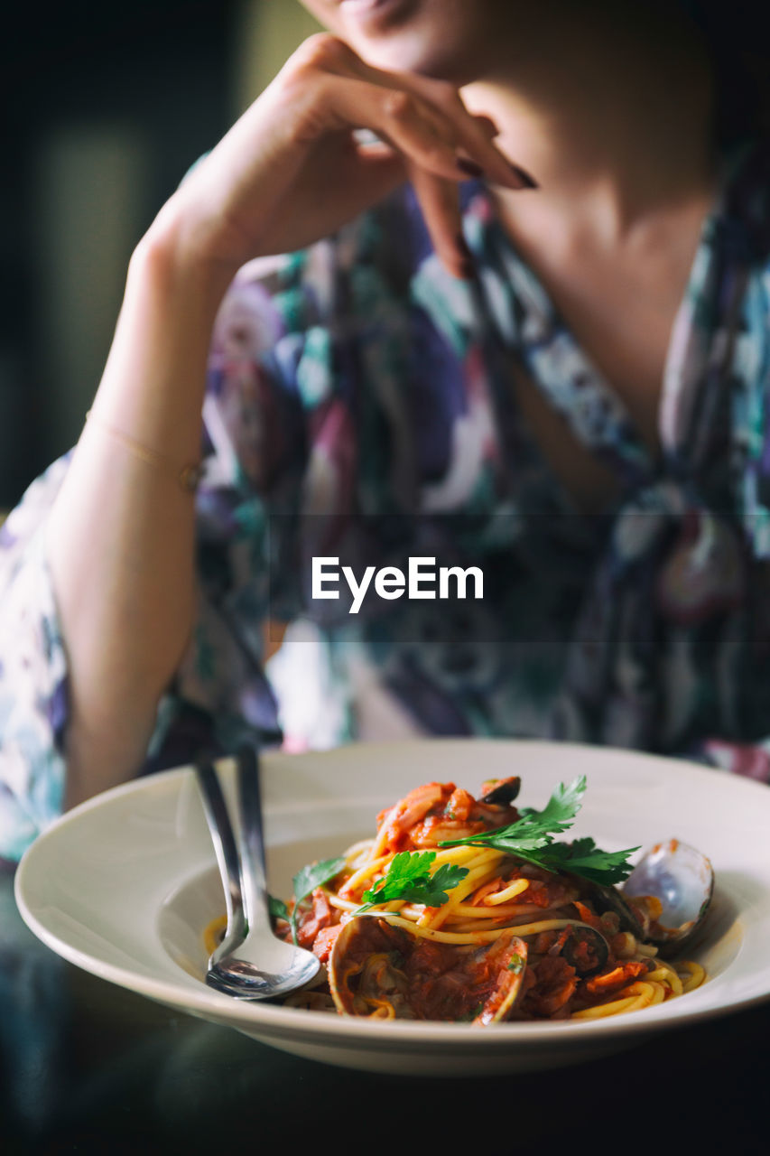 Midsection of woman with meal at table