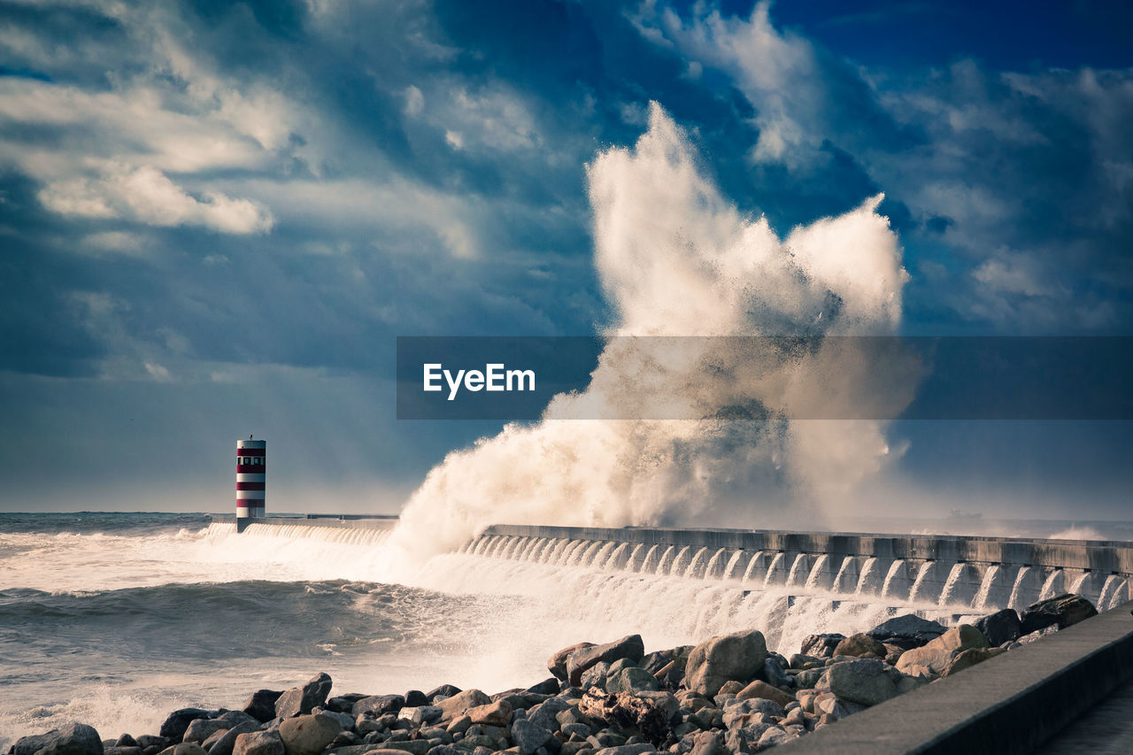 Scenic view of huge wave crashing against breakwater