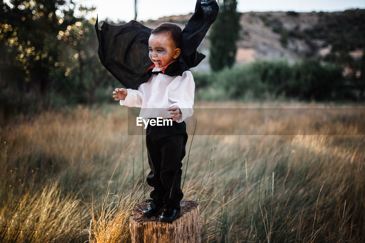 BOY STANDING ON FIELD