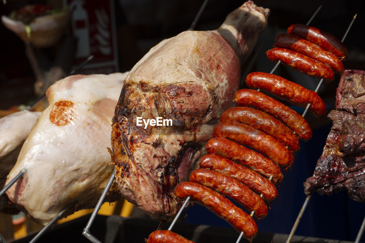 CLOSE-UP OF MEAT COOKING ON BARBECUE GRILL