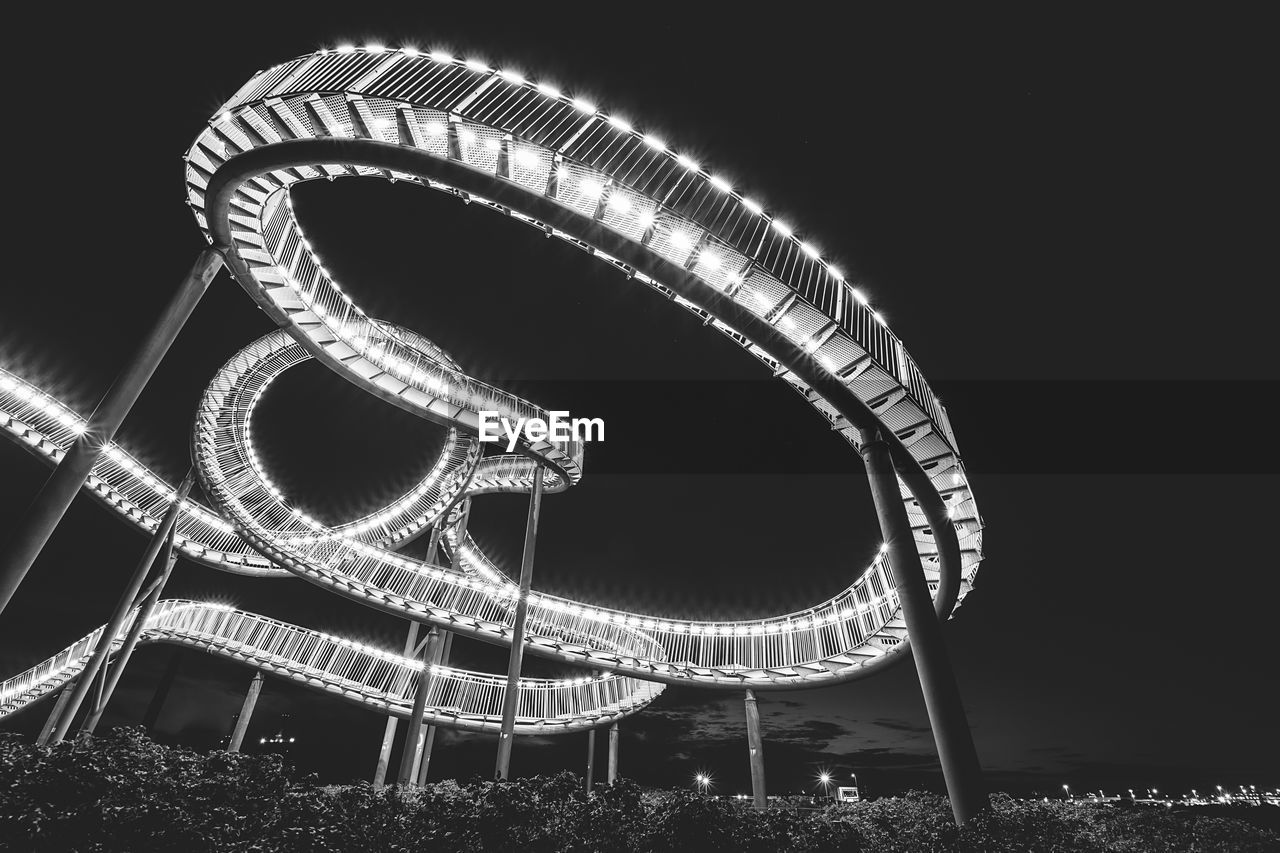 LOW ANGLE VIEW OF ILLUMINATED CAROUSEL AGAINST SKY AT NIGHT