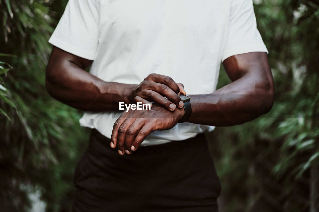 Sportsman checking smart watch while standing outdoors