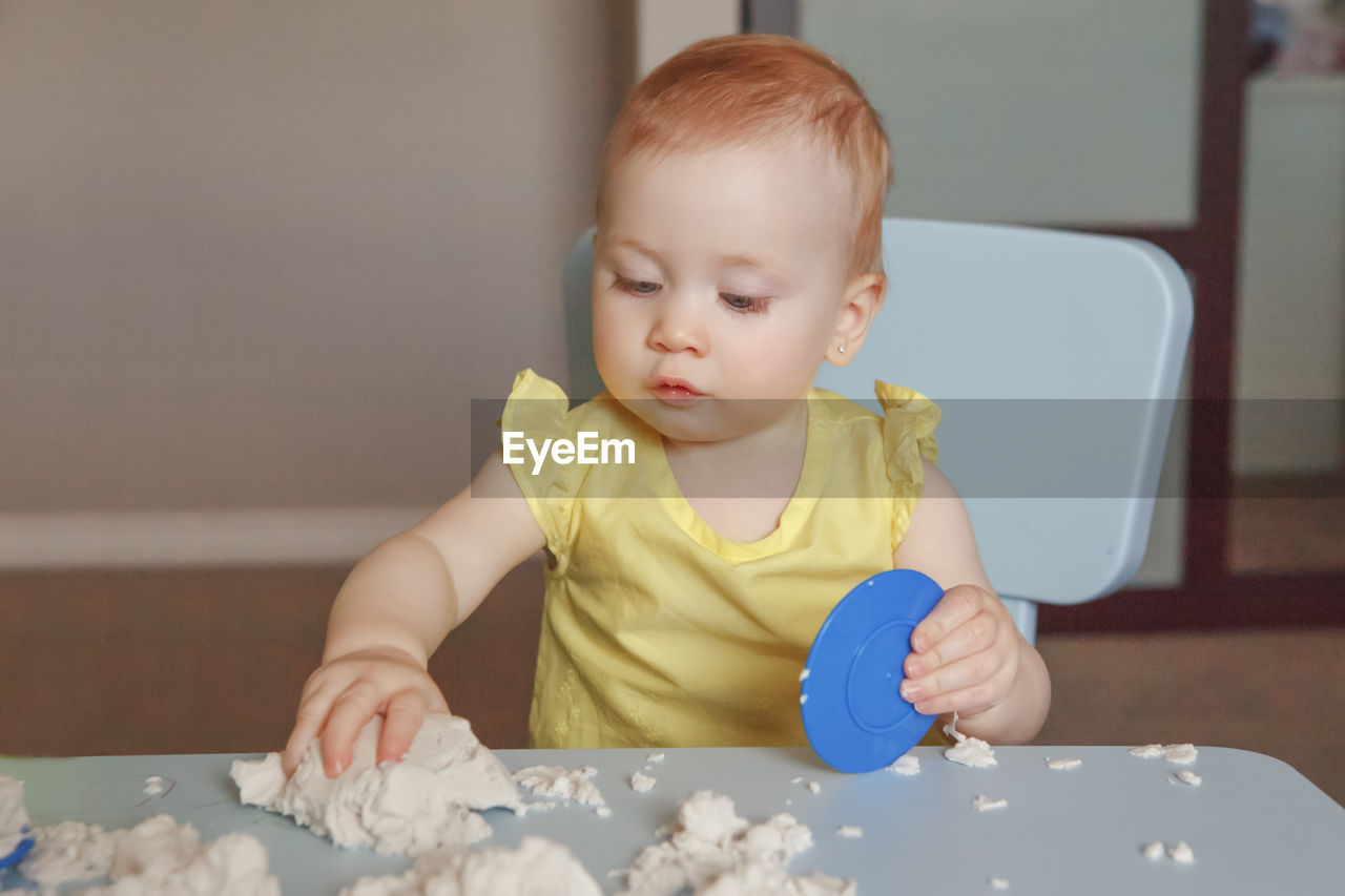 Cute baby boy looking at table