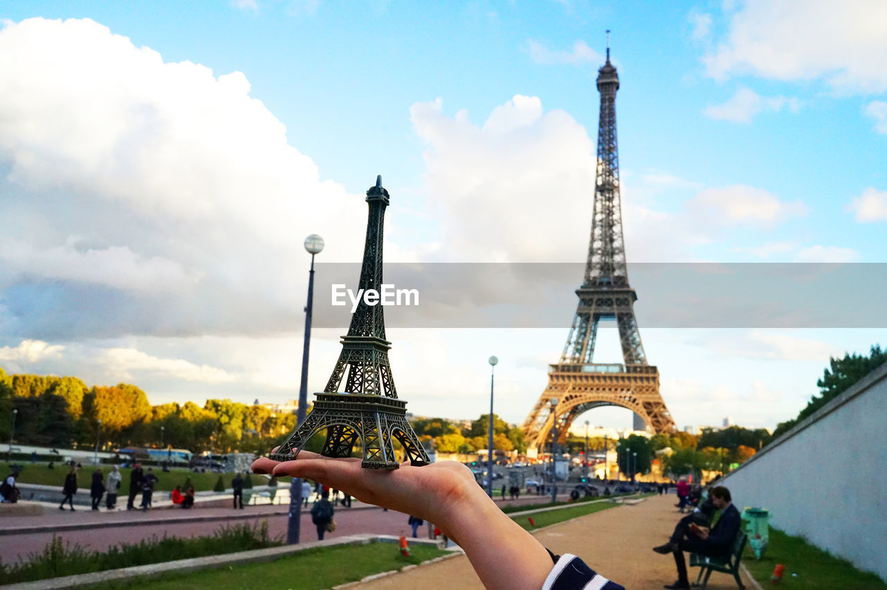 PEOPLE HOLDING TOWER AGAINST SKY