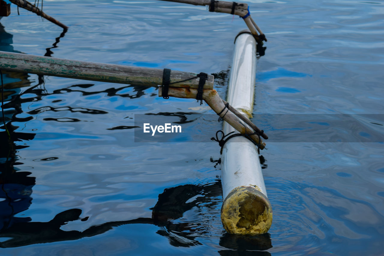 HIGH ANGLE VIEW OF METAL RAILING IN LAKE