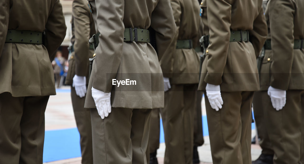 Midsection of soldiers standing outdoors