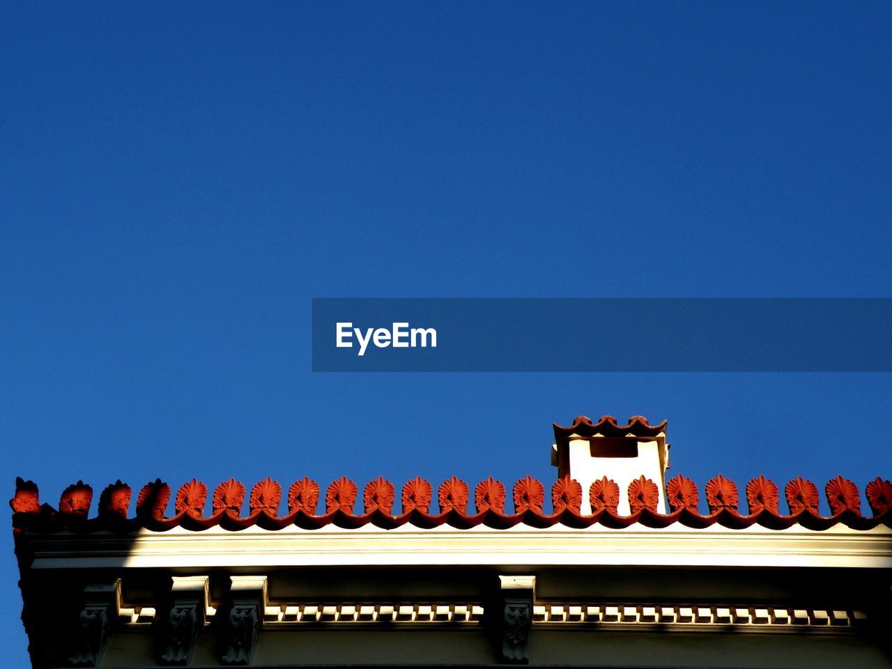 High section of built structure against clear blue sky