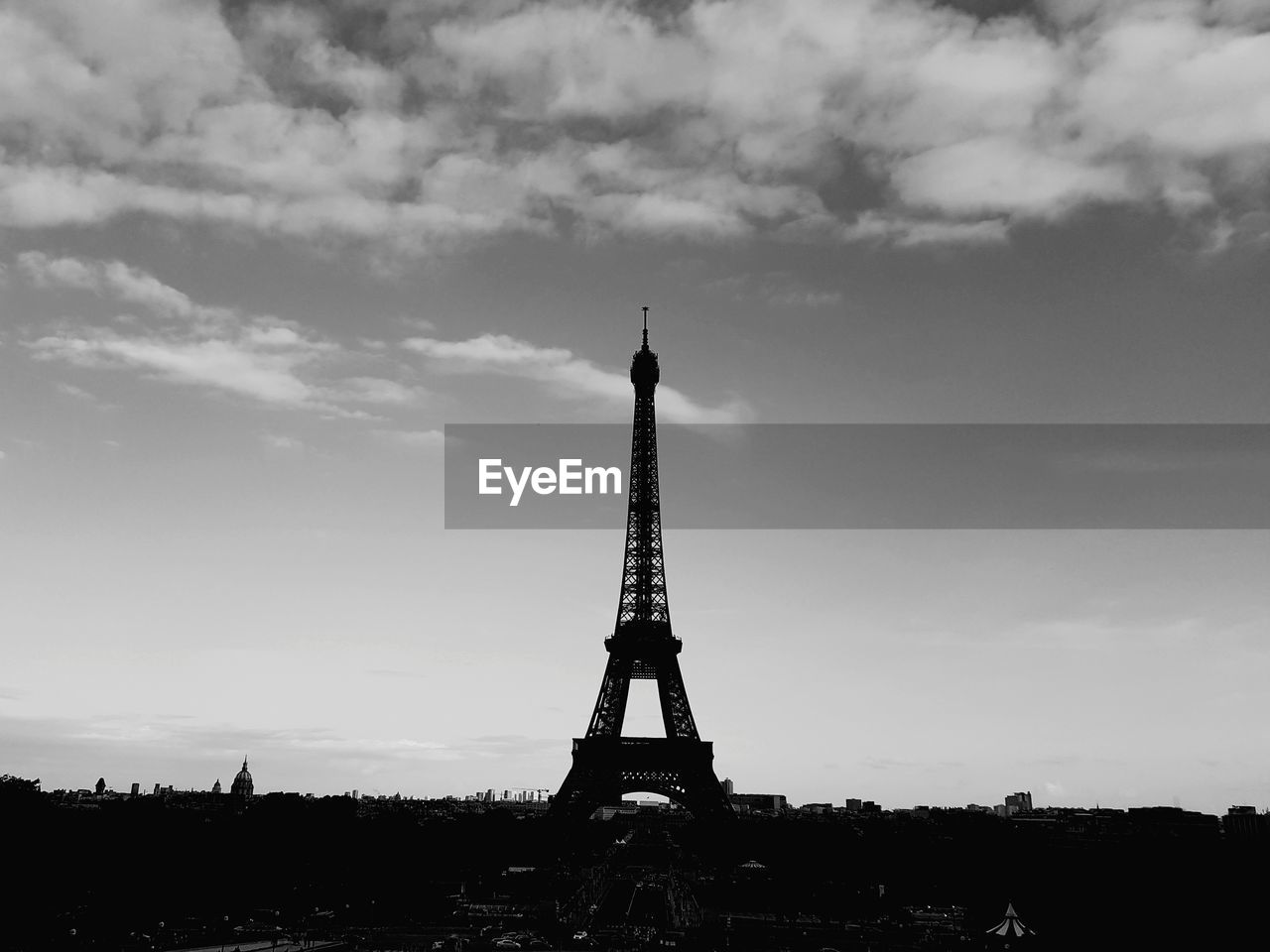 Silhouette eiffel tower against cloudy sky