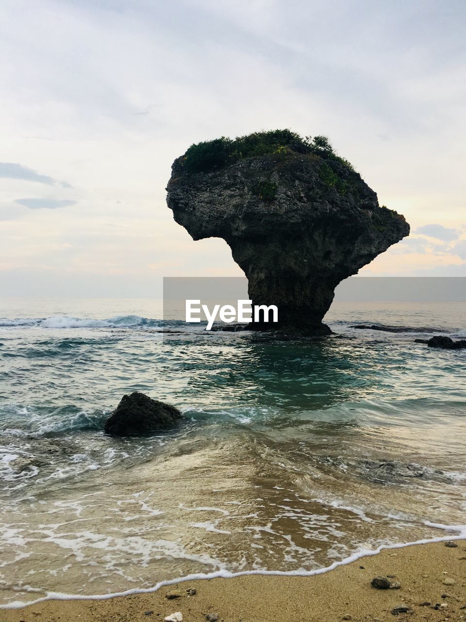 Rock formation on beach against sky