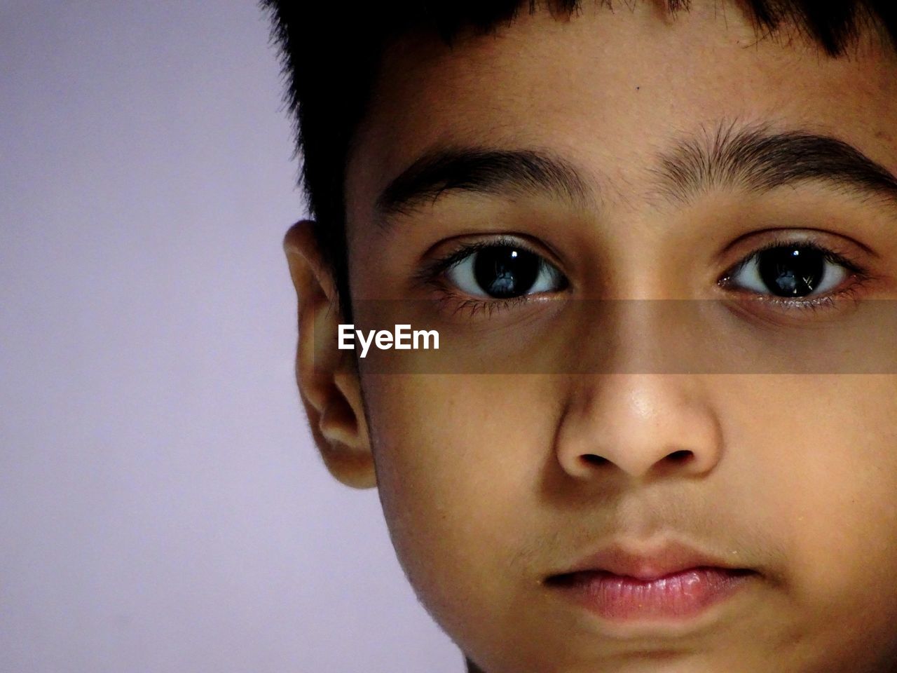 Close-up portrait of boy against purple background