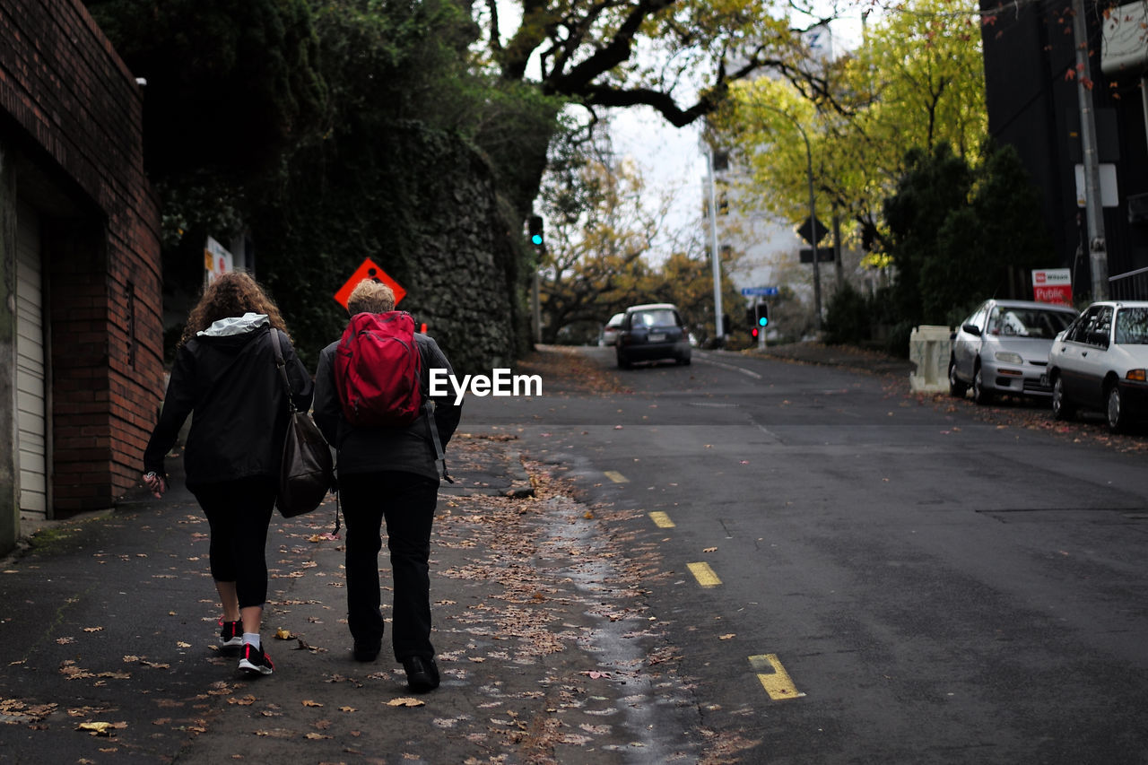 Rear view of woman walking on sidewalk