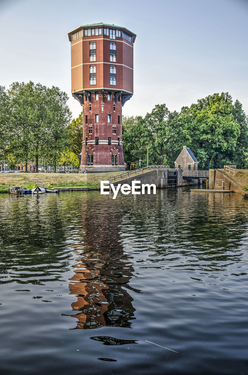 Converted watertower reflecting in canal on a summer evening