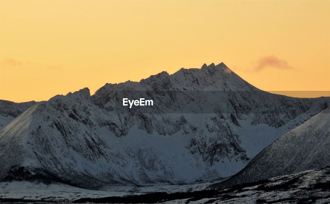 Scenic view of snowcapped mountains against sky during sunset