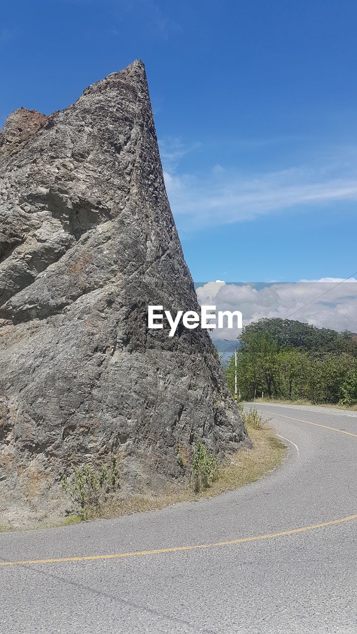 ROAD BY MOUNTAINS AGAINST SKY