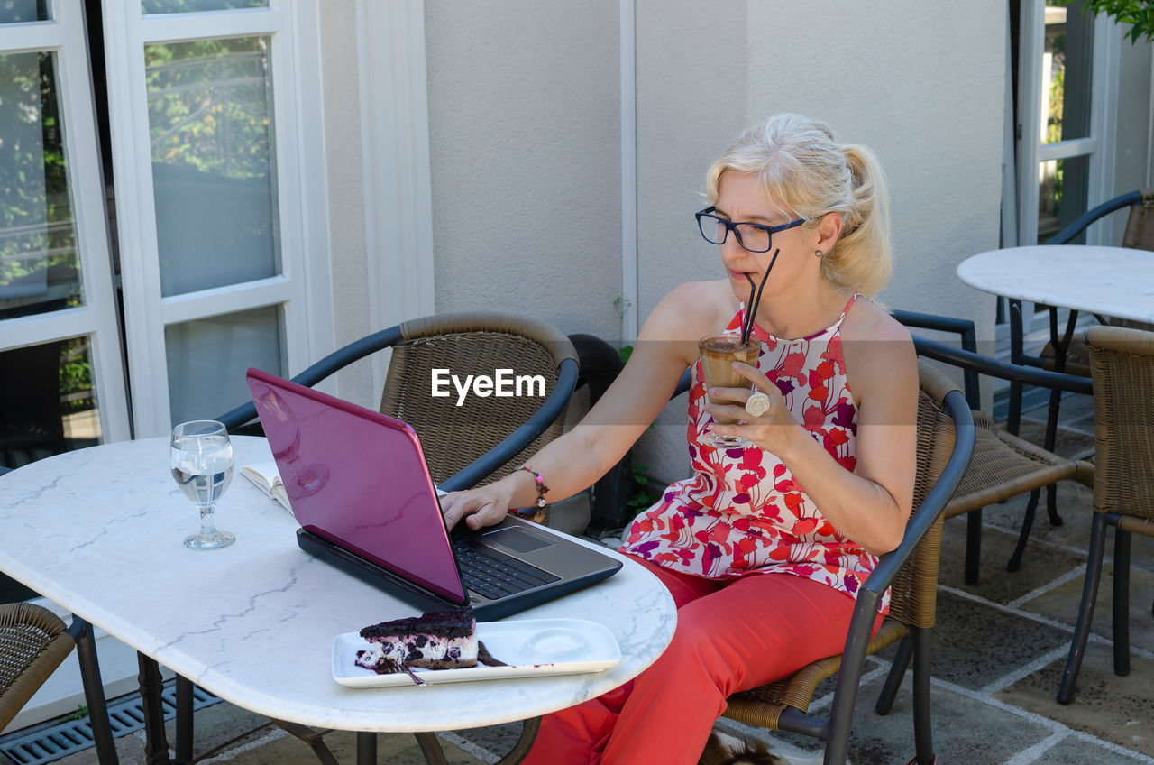 Woman working with technology outside an office