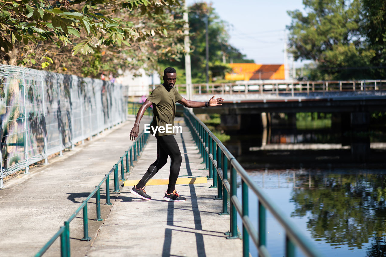 Man walking on footpath by canal