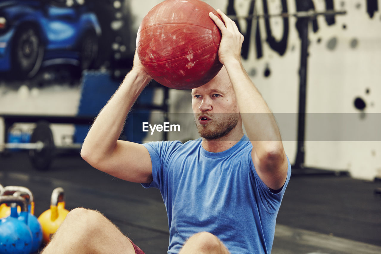 Man training in gym with medicine ball