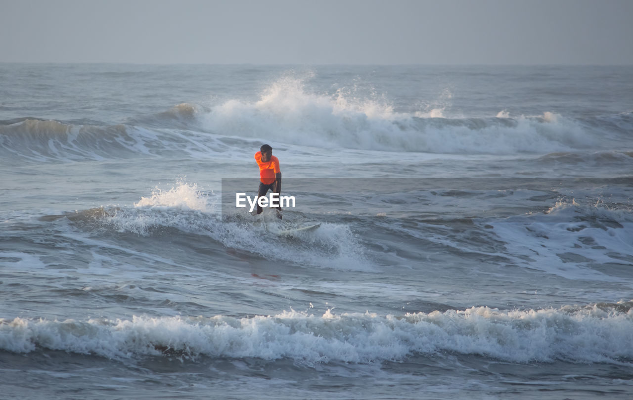 MAN SURFING IN SEA