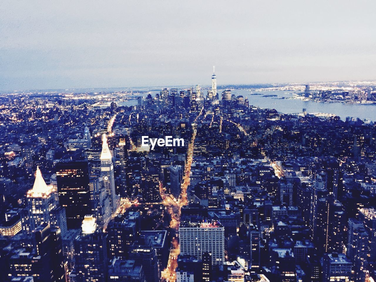 HIGH ANGLE VIEW OF CITY LIT UP AT DUSK